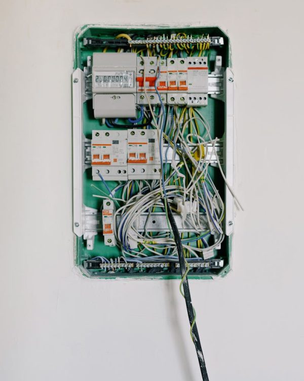 Detailed view of an open electrical circuit box with complex wiring and circuit breakers.